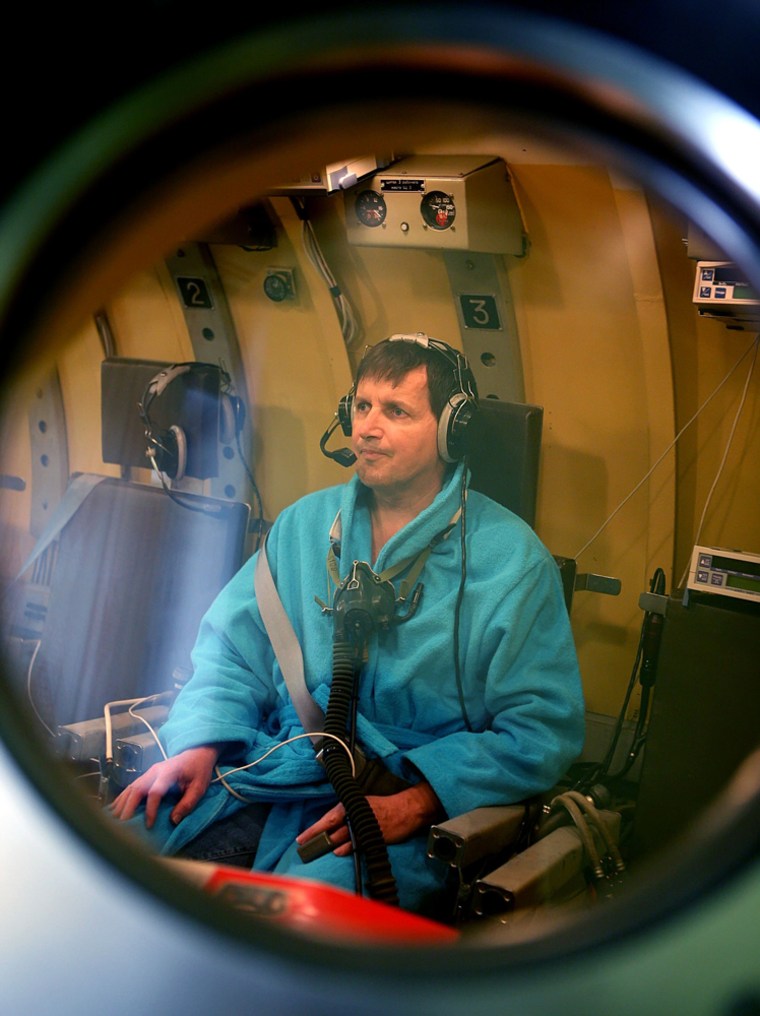 Simonyi, a former software developer at Microsoft, is seen through the window of a pressure chamber during a training session in Star City near Moscow