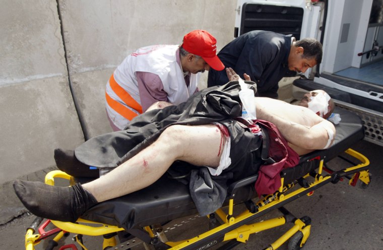 Iraqi hospital workers wheel a wounded m