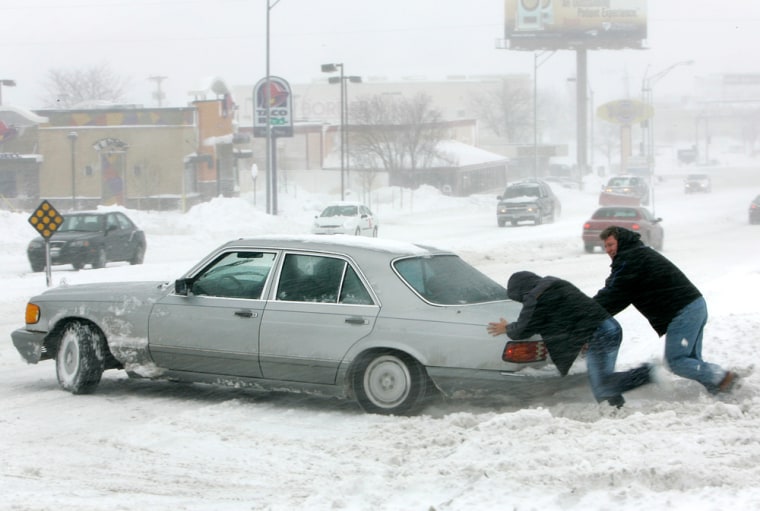 A car gets a human assist in Omaha, Neb., on Thursday. Heavy snow and gusty winds were expected to continue into Friday across much of the Midwest, dumping up to 16 inches of snow in some parts of Iowa before heading into Wisconsin. 