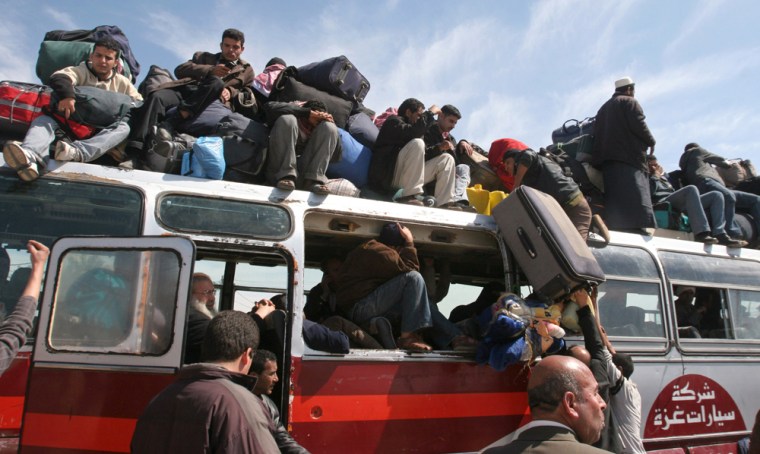 Palestinians throng inside and on top of a bus at the Rafah border crossing from the Gaza Strip into Egypt on Thursday. Citing security threats, Israel allows the Rafah crossing, Gaza's only gateway to the outside world, to operate only sporadically, leading to huge crowds on the rare occasions it opens. 