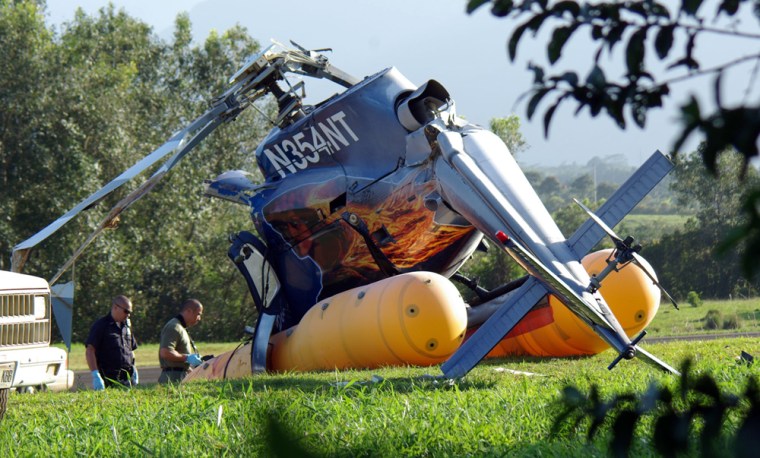 Investigators examine the wreckage of a tour helicopter that crashed Thursday, near Princeville Airport on Kauai, Hawaii, killing four people and critically injuring three.