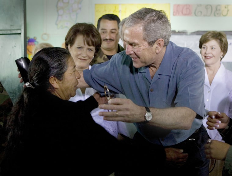 US President George W. Bush reaches to h
