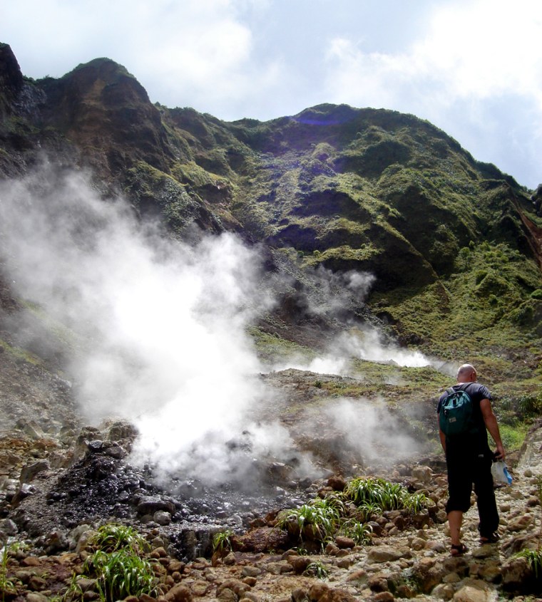 A hiker makes his way in the Valley of Desolation on Dominica October 2006. The the Valley of Desolation is an eerie, treeless swath of volcanic devastation striped black and orange with mineral deposits and swirling with mist and steam. (AP Photo/Jill Lawless)
