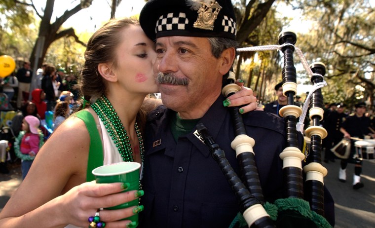 Christy Coberly of Savannah, Ga., kisses Long Island, N.Y., Police Pipe and Drum Band member George Lago on the cheek Saturday during the annual St. Patrick's Day parade in Savannah. 