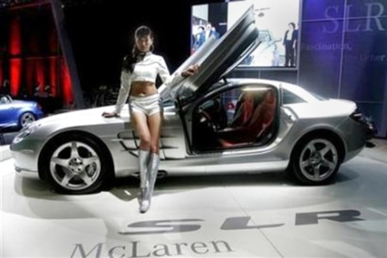 A model poses next to a Mercedes Benz's SLR McLaren at the 2005 Seoul Motor Show. South Korean automakers plan to cut down on the number of scantily clad models at the car show, hoping people will look at the cars instead.