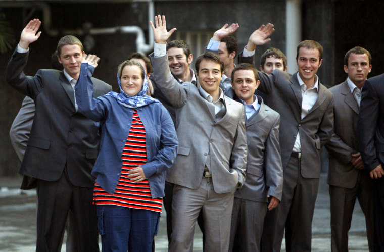 British navy personnel, seized by Iran, wave to the media after their meeting with the Iranian President Mahmoud Ahmadinejad at the presidential palace in Tehran on Wednesday.