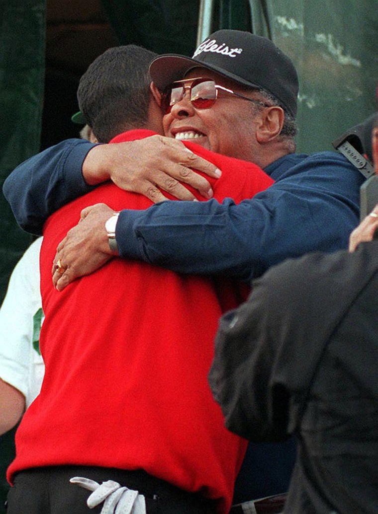 Tiger Woods (L) is hugged by his father Earl Woods