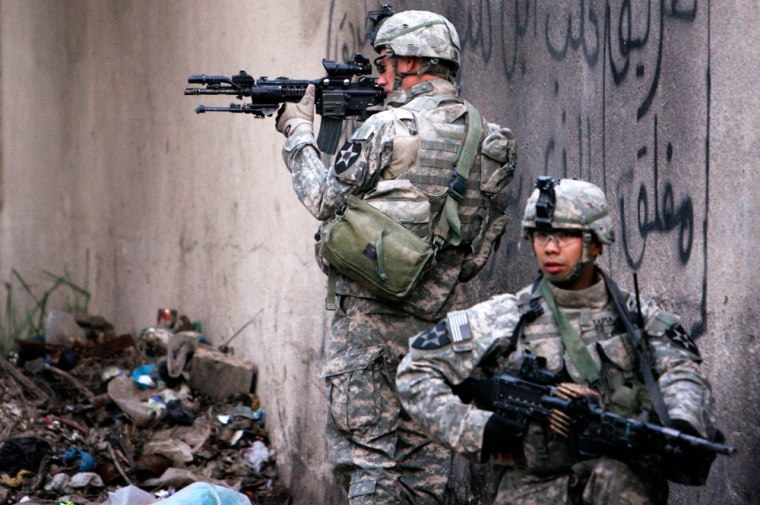 Specialists Koontz and Tapia with the U.S. Army's 3-2 Stryker Brigade keep watch on a street during a patrol in Baghdad