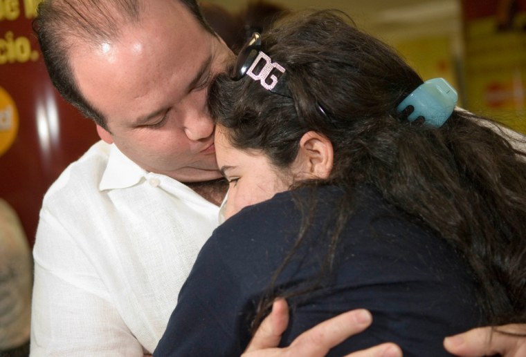 Valentina Dao, 17, is embraced by her father, Andres Dao, after her arrival at Miami International Airport on Saturday. Valentina had been aboard the Sea Diamond, a Greek-flagged cruise ship that hit a reef and sank Thursday off an Aegean Sea island. 