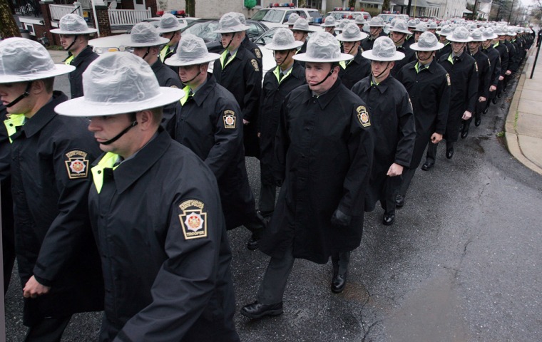 Pennsylvania state troopers march Thursday to the Hill School Center for the Arts in Pottstown, Pa., for the funeral services of slain FBI Special Agent Barry Lee Bush, 52, shot to death on April 5, as he and other agents tried to apprehend bank robbers.