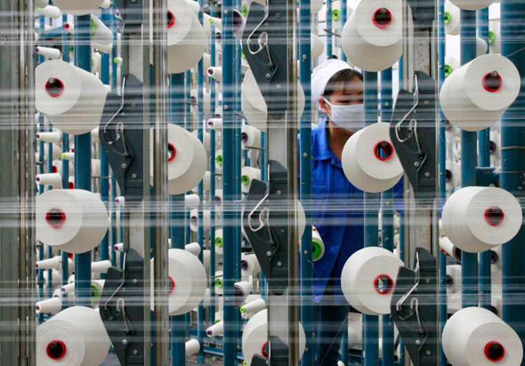 A labourer works at the workshop of a textile factory in Suining