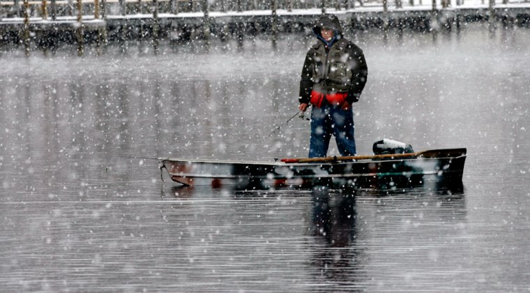 Matt Littlefield of Ogunquit, Maine, fishes for salmon on Lake Winnipesaukee as a spring snowstorm passes through Alton, N.H., on Thursday.