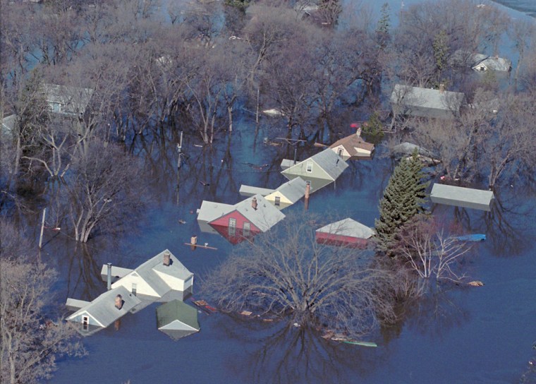 Flood waters of the rising Red River submerges homes on April 19, 1997 in Grand Forks, N.D., where thousands were evacuated due to the flooding. Ten years later, heavy rain and snow still make people nervous but a $400 million dike system, nearly finished, is bringing some comfort. 