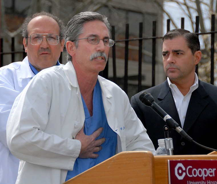Tom Shea, right, chief of staff for New Jersey Gov. Jon Corzine, watches as Dr. Robert F. Ostrum, director of orthopedic trauma at Cooper University Hospital, answers questions about Corzine's condition after surgery, during a news conference outside the hospital in Camden, N.J., on Saturday.