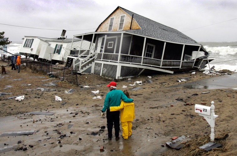 Residents view the damage done to two homes destroyed by a severe nor'easter that lashed the East Coast, Tuesday, April 17, 2007, in the Ferry Beach section of Saco, Maine. The homes are on the verge of being swept into the ocean. (AP Photo/Robert F. Bukaty)