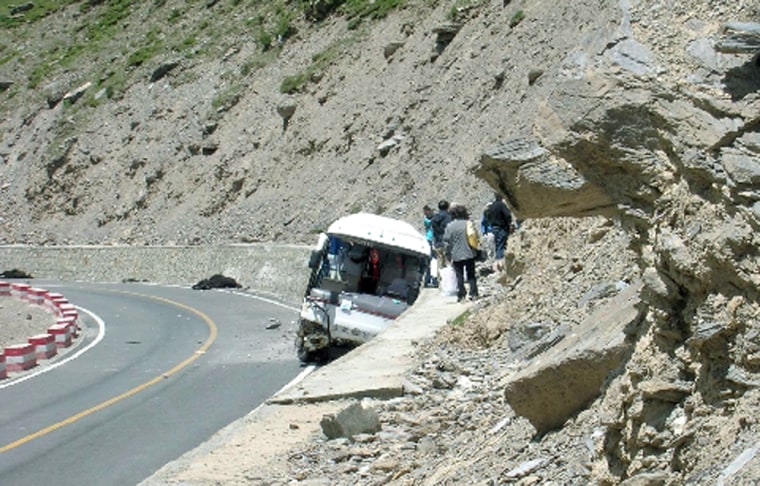 A tour bus rests after striking a herd of yaks and then a retention wall after losing its brakes.