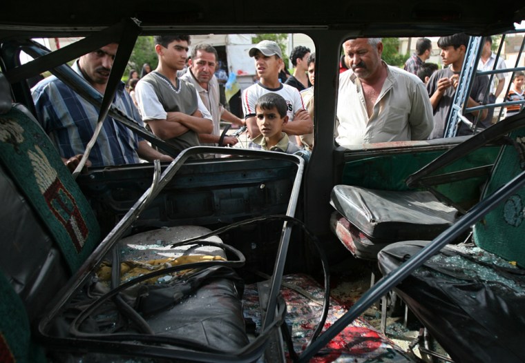 Iraqis inspect a damaged vehicle following a car bomb explosion in Baghdad on Thursday. A parked car bomb exploded in the Jadriyah neighborhood, killing eight civilians and wounding 19 others. 
