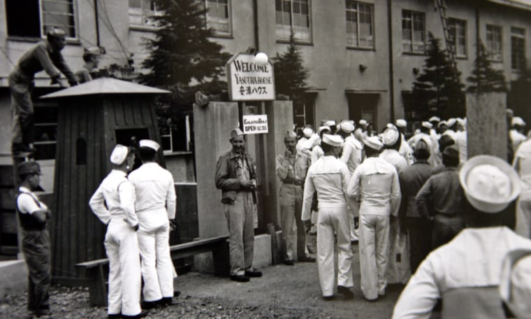In this undated image released by the Yokosuka City Council in Japan, U.S. sailors gather in front of a Yasu-ura House "comfort station" in Yokosuka, south of Tokyo. 