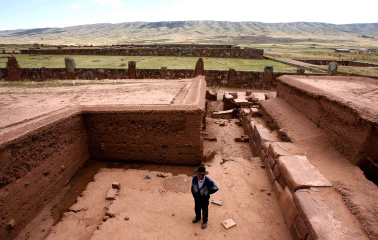 An archaeologist walks near the base of the much-looted Akapana pyramid