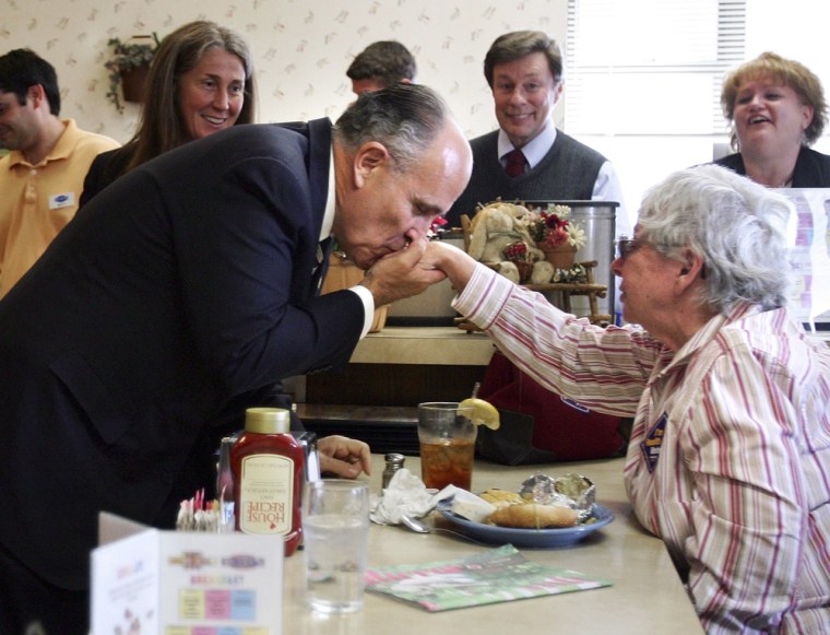Republican presidential candidate and former New York City mayor Giuliani kisses the hand of Guenther during a campaign stop in Manchester
