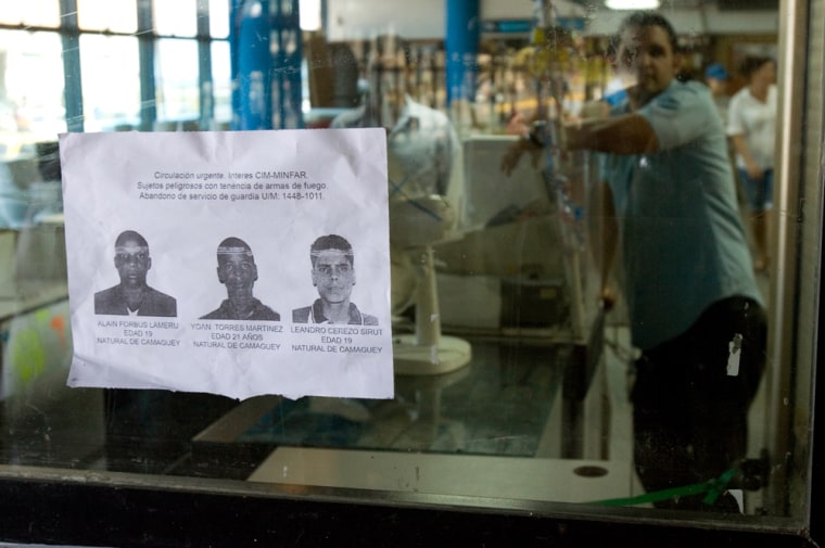 A poster showing three wanted Cuban soldiers sits on a window in front of a hardware shop in Havana on Thursday. The soldiers are accused of trying to hijack a U.S.-bound plane.