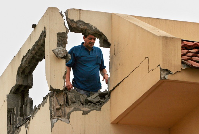 An Israeli examines damage to his home after it was hit by a rocket fired by Palestinian militants in Gaza, in the southern Israeli city of Sderot, on Saturday.