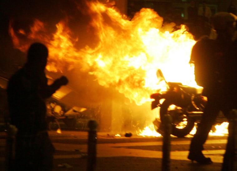 Youths burn a motorbike on the Place de la Bastille in Paris, Sunday, May 6, 2007. Riot police fired tear gas into a crowd gathered at the Place de la Bastille following conservative Nicolas Sarkozy's presidential election victory Sunday and dispersed another angry group in Lyon. (AP Photo/Michel Spingler)