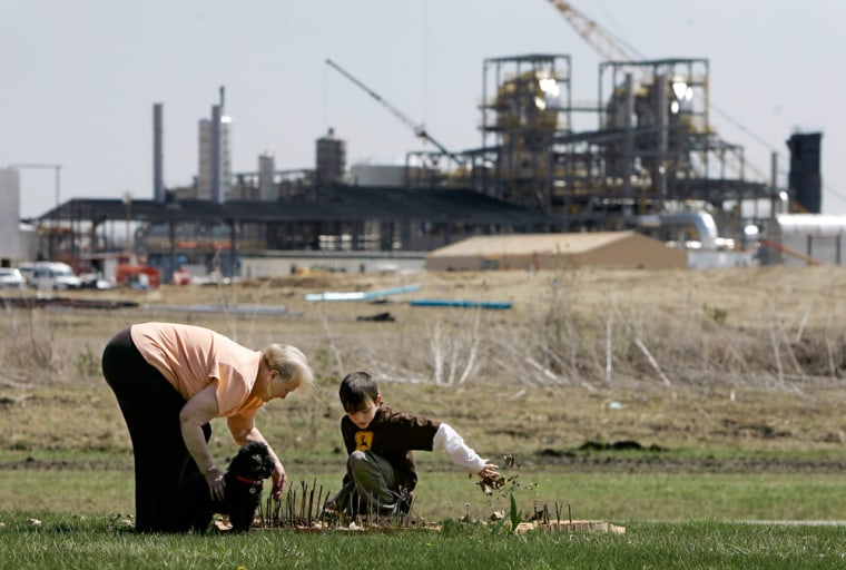Jenny Newton pulls weeds with her grandson, Radier Newton, on April 17 as work continues on an ethanol refinery near her home in Portland, Ind. Newton does not care for the $175 million plant.