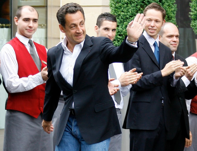 France's newly-elected President Nicolas Sarkozy leaves the Fouquet's Hotel in Paris