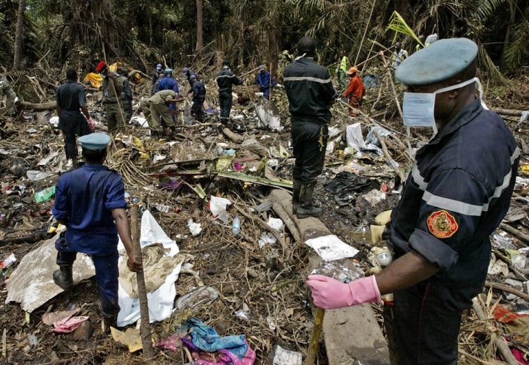 Rescue workers search through the wreckage at the crash site of the Kenya Airways plane in Mbanga Pongo, Cameroon, on May 8. There were no survivors.