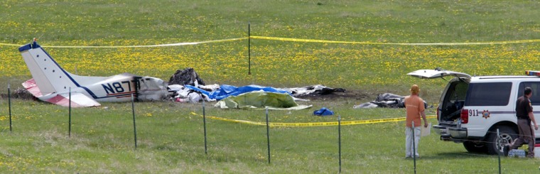 Flathead County Sheriff's deputies stand beside the wreckage of a plane that crashed at Lost Praire Skydive Center on Saturday outside Marion, Mont. 