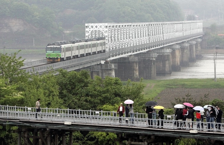 Tourists watch a train running on the rail link betwen North and South Korea.