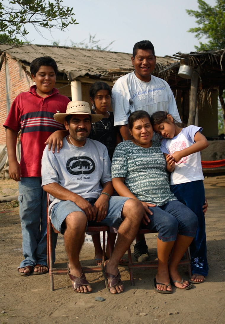 Pedro Ramirez and his wife, Isabel Aguirre sit with their children Adrian, 12, left, Yadira, 10, center top, Pedro, right top, and Adriana, 7, right, as they pose for a photograph Thursday at their new home in Cancita, Mexico.