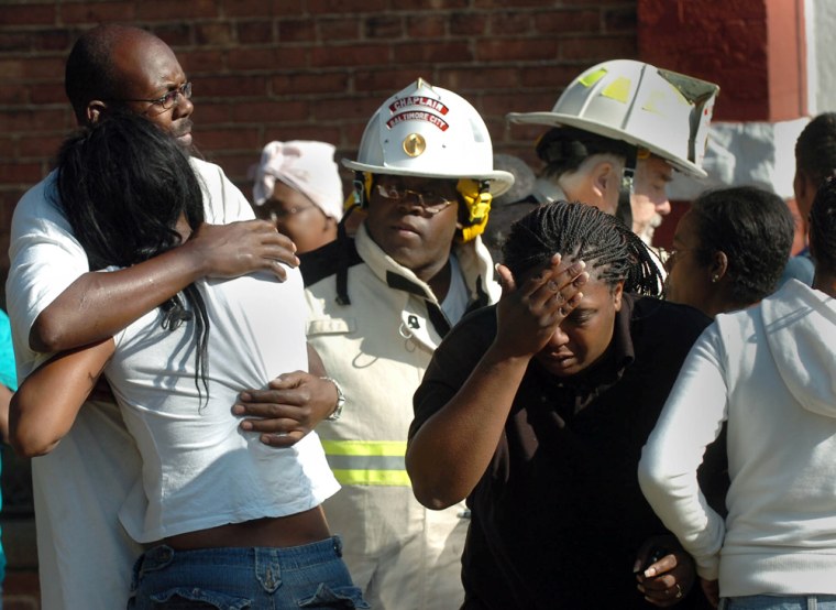 Baltimore City Fire Department chaplains try on Tuesday to comfort relatives of victims near the scene of a fire that engulfed a two-story row house in Baltimore, Md., killing at least six people and injuring seven others, authorities said. 