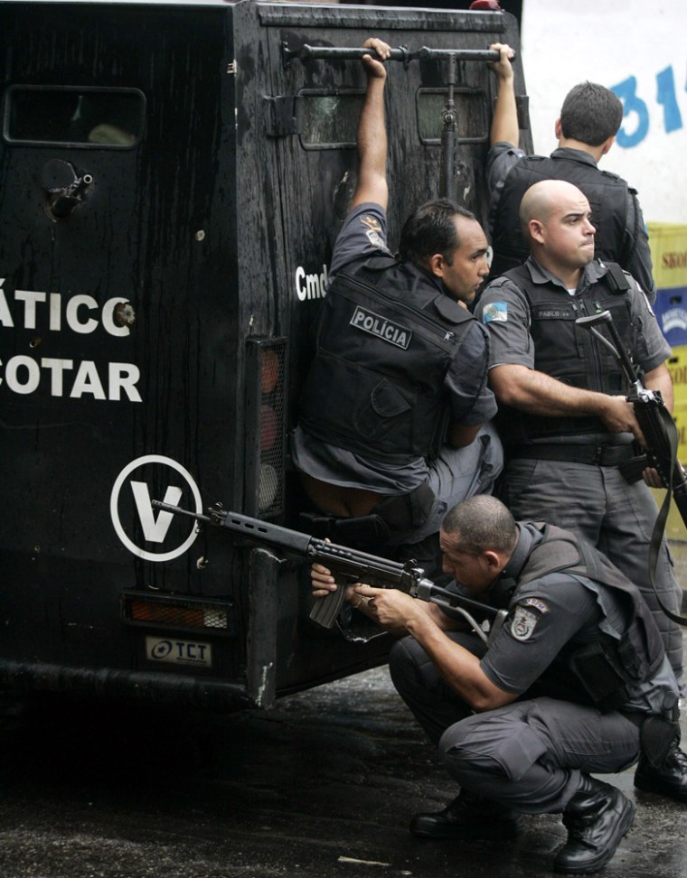 Brazilian police officers take up positions during an operation at Favela da Grota in Rio de Janeiro