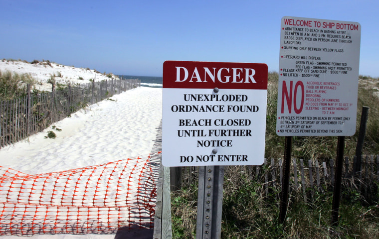 Signs are seen May 15 next to a closed pathway to the beach in Ship Bottom, N.J.
