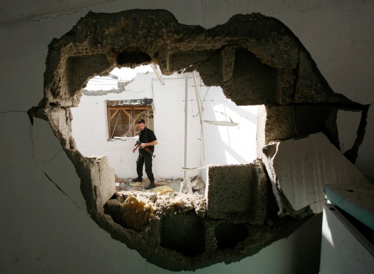 Member of Hamas' Executive Force inspects damaged compound after an Israeli air strike in Gaza