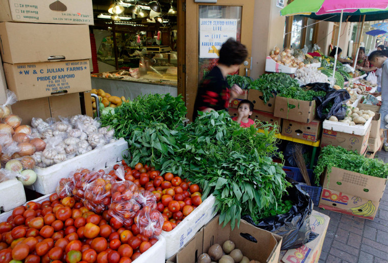 ** FOR IMMEDIATE RELEASE **A shopper walks past a little boy at the Kekaulike Market in Chinatown, May 17, 2007 in Honolulu.  The market sells everything from fresh local vegetables and seafood, beef and pork, and Asian spices.  Shedding a history filled with prostitution, gambling dens and streets plagued by drug dealers, Honolulu's Chinatown neighborhood once walked by the fictional detective Charlie Chan has finally begun to emerge from its dark past.  (AP Photo/Marco Garcia)