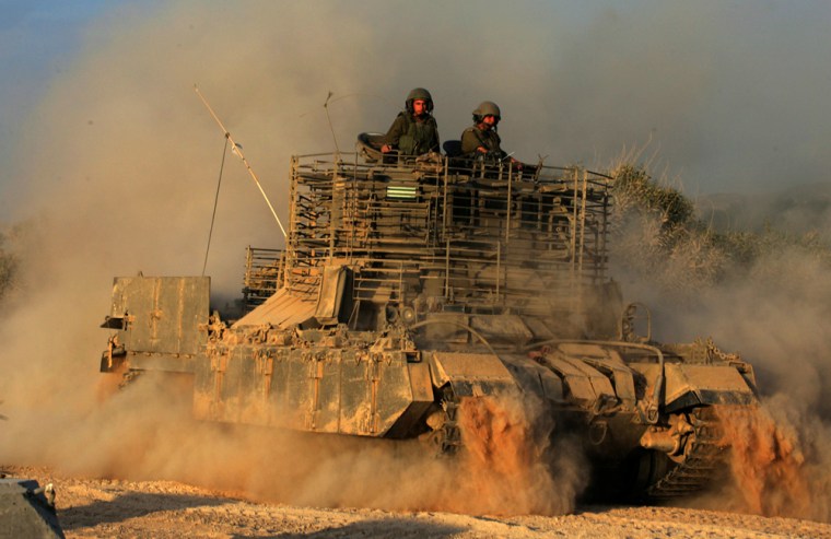 Israeli soldiers sit on top of an armore