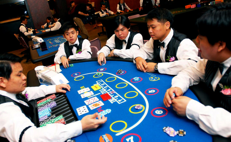 Casino school graduates from the International Club Games Training Center practice their skills in Singapore. In 2005, Singapore legalized casino gambling and two casino resorts will open in 2009 and 2010. 