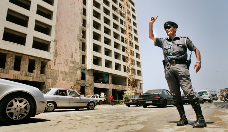 A Lebanese traffic policeman on Thursday directs the first traffic over the site on the Beirut seaside boulevard where a suicide truck bomb exploded next to Rafik Hariri's motorcade on Feb. 14, 2005, killing him and 22 others. The site had been sealed off to civilians while a U.N. probe looked for evidence.