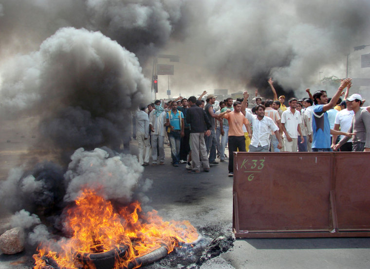 Protesters burn tires in the middle of a road in Gurgaon, on the outskirts of New Delhi, India, Wednesday. Angry villagers blocked highways and railroad lines in northwestern India for a third day Thursday as the death toll from clashes with police rose to 18. 