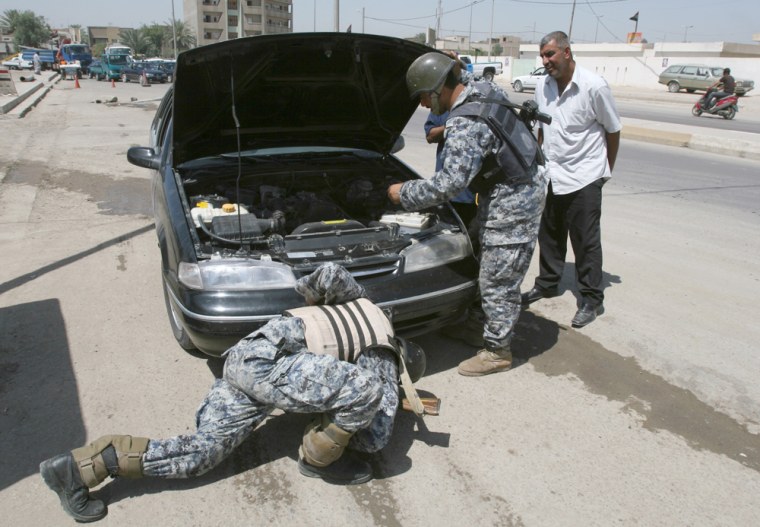 Iraqi policemen search a car at a check point in Sadr City, Baghdad, Iraq, on Wednesday, June 6, 2007. Car bombings shook the streets leading to Baghdad's most revered Shiite Muslim shrine on Wednesday, and police reported at least seven people killed and 27 others wounded.(AP Photo/Karim Kadim)