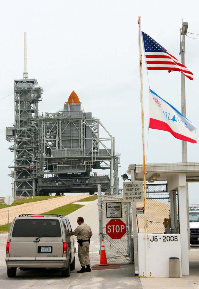 A NASA guard stops a vehicle before it heads up to the space shuttle Atlantis at Kennedy Space Center in Cape Canaveral