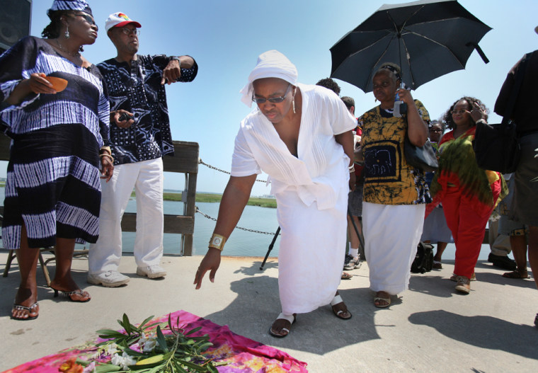 Jakki Jefferson, of Charleston, S.C., places flowers in remembrance of the African slaves who died during the "Middle Passage" during the 10th Annual remembrance program on Sullivan's Island, S.C., on Saturday.