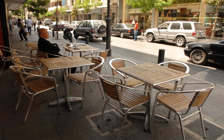 A man sits in a nearly empty street cafe in Beirut's Hamra district, in Lebanon. Last summer it was Israeli airstrikes and Hezbollah rockets. This year, it's al-Qaida-inspired militants and explosions keeping tourists away.