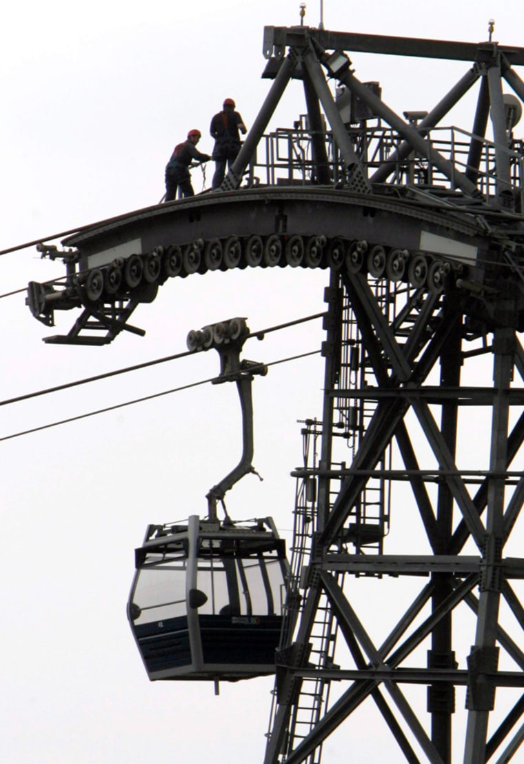 Workers inspect a tower from 'Ngong Ping 360', a cable car journey up to a giant bronze Buddha on Lantau island, Hong Kong