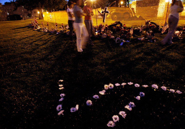 Visitors walk past a makeshift memorial for the Virginia Tech shooting victims on university's campus in Blacksburg, Va., on Wednesday night.