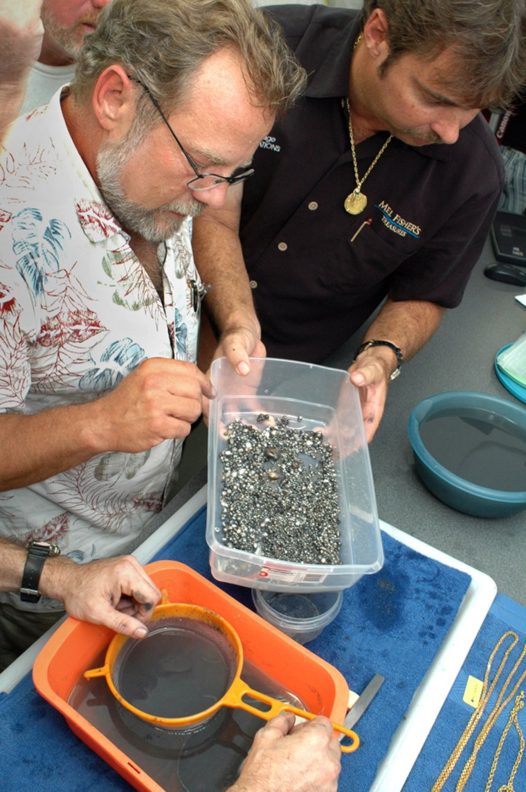 Archaeologist James Sinclair inspects pearls  found when a lead box was opened in Key West, Fla., on Friday. At right is Gary Randolph of Mel Fisher's Treasures.