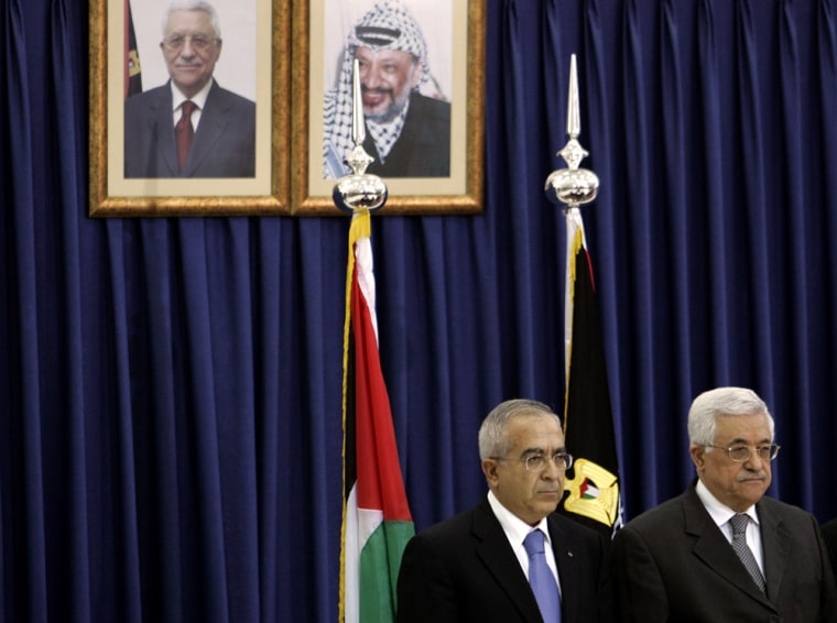 Palestinian President Mahmoud Abbas, right, and newly-appointed Palestinian Prime Minister Salam Fayad attend a swearing-in ceremony for the new government at Abbas' headquarters in the West Bank city of Ramallah on Sunday.